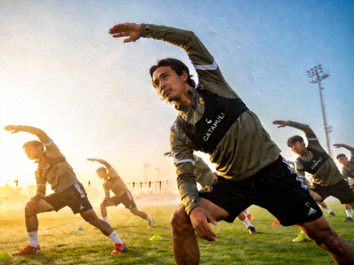 乐竞俱乐部球员在清晨阳光下进行集体热身拉伸运动