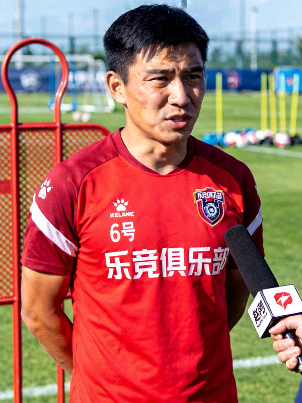 乐竞俱乐部6号中场赵刚在训练场边接受采访，表情坚毅