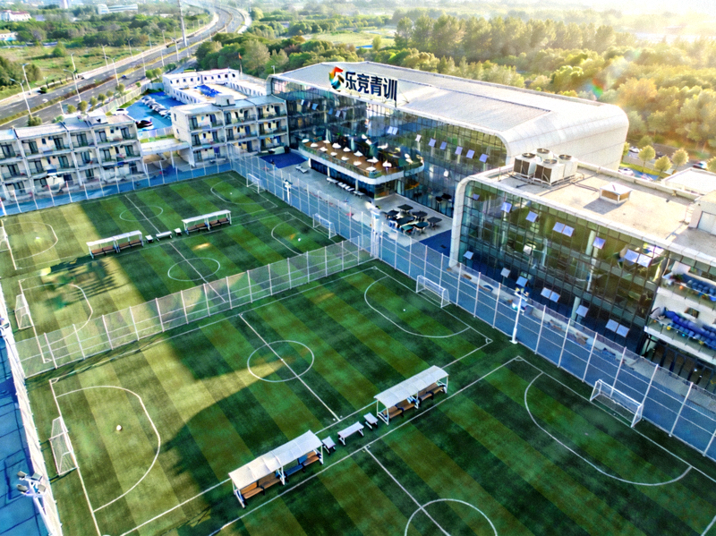 乐竞俱乐部青训基地鸟瞰图，展示多块标准训练场和现代化建筑