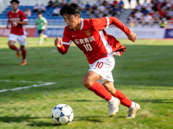 乐竞青训U19梯队中场核心李晓在比赛中带球突破的瞬间