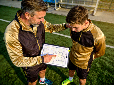 助理教练在场边对年轻球员进行一对一技术指导